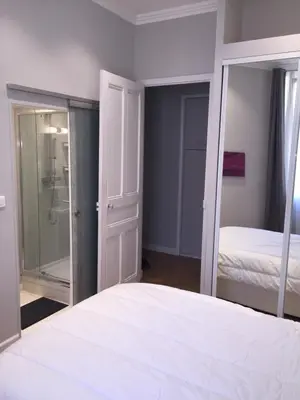 a bedroom with a white bed and a mirror at central CANNES - Luxury Clara Residence in Cannes