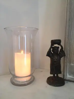 a candle and a statue next to a glass vase at central CANNES - Luxury Clara Residence in Cannes