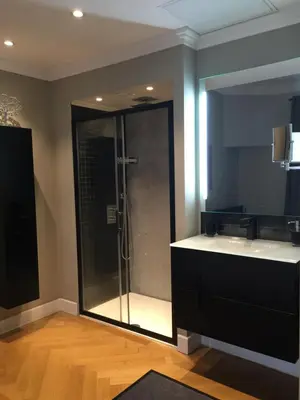a bathroom with a glass shower with a sink at central CANNES - Luxury Clara Residence in Cannes