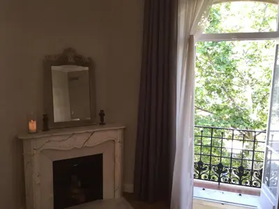 a room with a fireplace with a mirror and a window at central CANNES - Luxury Clara Residence in Cannes