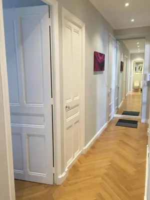 a hallway with white doors and wood floors at central CANNES - Luxury Clara Residence in Cannes
