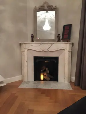 a living room with a fireplace with a mirror at central CANNES - Luxury Clara Residence in Cannes