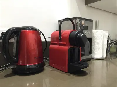 a red appliance sitting on a counter next to a microwave at central CANNES - Luxury Clara Residence in Cannes