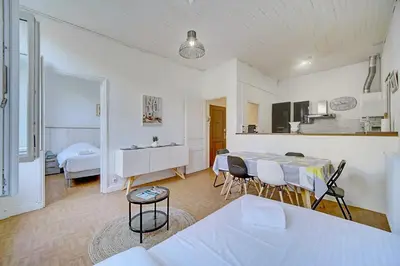 a living room with a table and chairs in a room at IMMOGROOM - Suquet - 2 min from the beaches in Cannes