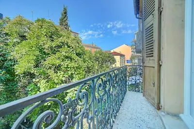 a balcony with a iron fence and bushes at IMMOGROOM - Suquet - 2 min from the beaches in Cannes