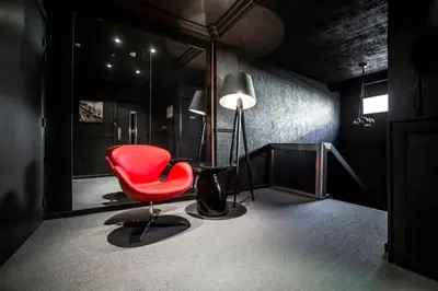 a room with a red chair and a lamp at Hotel Schtak in Cannes