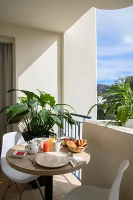 a table with a plate of food on a balcony at Le Cetai Cannes Beach Hotel in Cannes