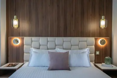 a bedroom with a large white bed with two lights at Le Cetai Cannes Beach Hotel in Cannes