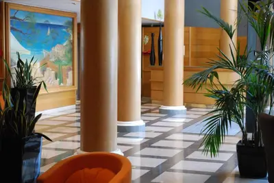 a lobby with columns and plants in a building at Le Cetai Cannes Beach Hotel in Cannes