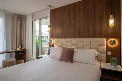 a bedroom with a large white bed and a window at Le Cetai Cannes Beach Hotel in Cannes