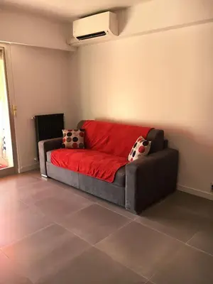 a couch in a living room with a red blanket at Studio Appartement Cannes Centre - 5 min à pied du Palais des Festivals et Congrès in Cannes