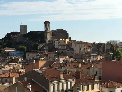 a city with a clock tower on a hill with buildings at Studio Appartement Cannes Centre - 5 min à pied du Palais des Festivals et Congrès in Cannes