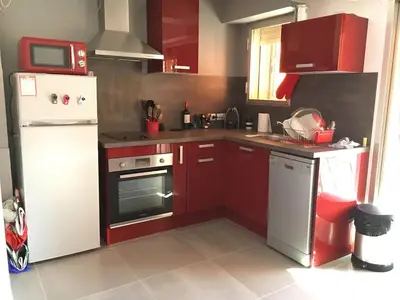 a kitchen with red cabinets and a white refrigerator at Studio Appartement Cannes Centre - 5 min à pied du Palais des Festivals et Congrès in Cannes