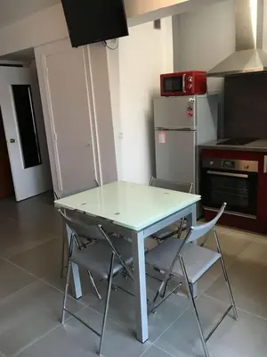 a kitchen with a white table and chairs in it at Studio Appartement Cannes Centre - 5 min à pied du Palais des Festivals et Congrès in Cannes