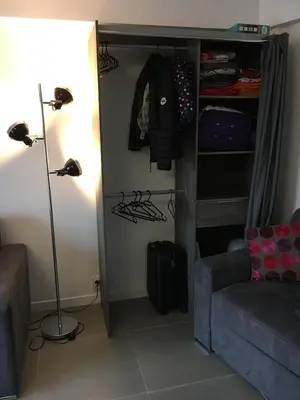 a room with a couch and a lamp and a closet at Studio Appartement Cannes Centre - 5 min à pied du Palais des Festivals et Congrès in Cannes
