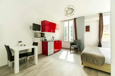 a room with a kitchen and a bed and a desk at Florella République Apartment in Cannes