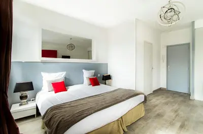 a bedroom with a large bed with red pillows at Florella République Apartment in Cannes