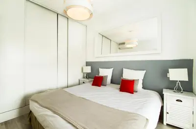 a bedroom with a large bed with red pillows at Florella République Apartment in Cannes