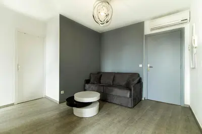 a living room with a couch and a stool at Florella République Apartment in Cannes