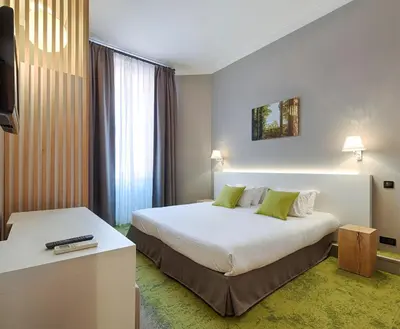a hotel room with a large bed and a television at Hôtel La Villa Tosca in Cannes