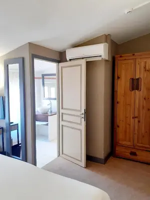 a bedroom with a white door and a air conditioner at Hôtel La Villa Tosca in Cannes