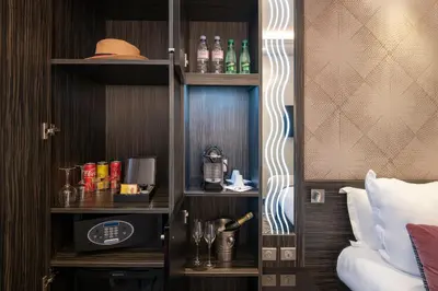 a hotel room with a shelf with bottles and glasses at BW Premier Collection Mondial in Cannes