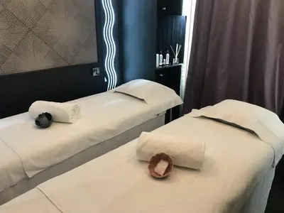 two beds with white sheets and a hat on them at BW Premier Collection Mondial in Cannes