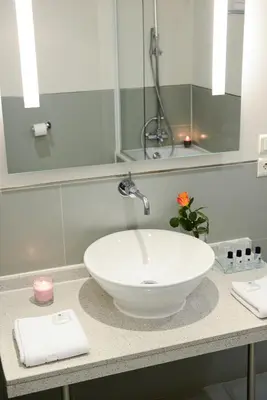 a bathroom with a white sink and a mirror at Hôtel Cannes Centre Univers in Cannes