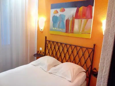 a bedroom with a bed and a painting on the wall at Hôtel Brimer Cannes in Cannes