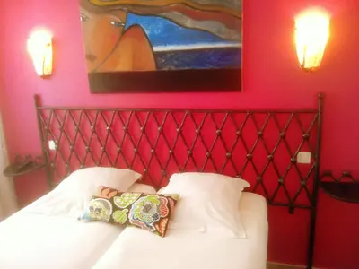 a bed with two pillows and a painting on the wall at Hôtel Brimer Cannes in Cannes
