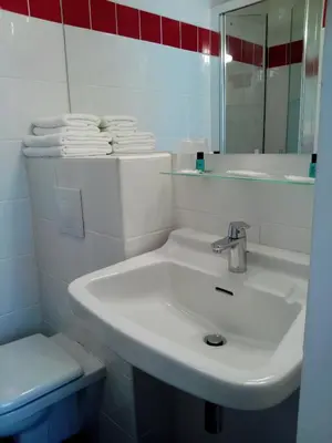 a white bathroom with a sink and a toilet at Hôtel Brimer Cannes in Cannes