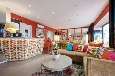 a living room with a couch and a table at Hôtel Brimer Cannes in Cannes