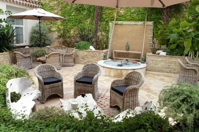 a patio with a fountain and chairs and an umbrella at Best Western Premier Le Patio des Artistes Wellness Jacuzzi in Cannes