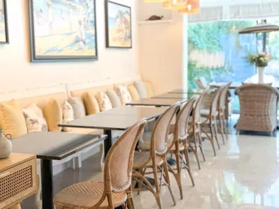a living room with wicker chairs and a table at Hôtel de Provence in Cannes