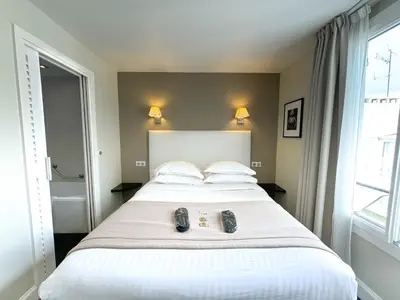 a hotel room with two beds and a desk and a computer at Hôtel de Provence in Cannes