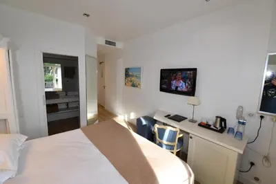 a bedroom with a large bed in a room at Hôtel de Provence in Cannes
