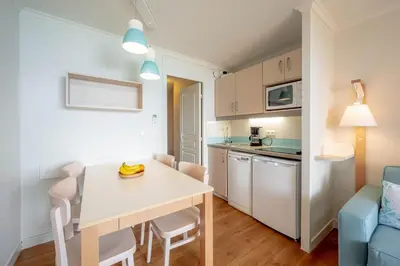 a kitchen and dining room with a white table and chairs at Résidence Pierre & Vacances Cannes Verrerie in Cannes