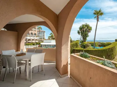 a balcony with a table and chairs and a view of the ocean at Résidence Pierre & Vacances Cannes Verrerie in Cannes