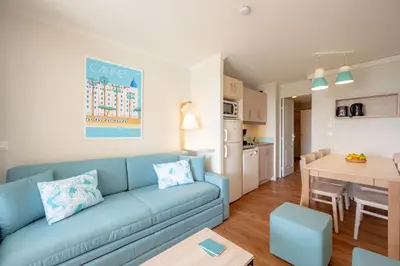 a living room with a blue couch and a table at Résidence Pierre & Vacances Cannes Verrerie in Cannes
