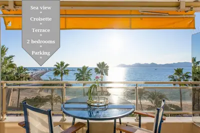 a table and chairs on a balcony with a view of the ocean at On La Croisette: new 2 bedrooms with sea view in Cannes