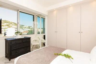a bedroom with a bed and a desk and windows at On La Croisette: new 2 bedrooms with sea view in Cannes