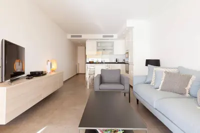 a living room with a couch and a tv at On la Croisette: luxe 2 bedrooms/ 2 baths in Cannes