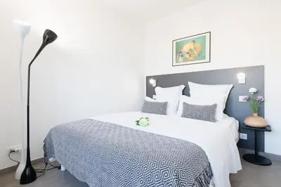 a bedroom with a bed with a white bedspread at On la Croisette: luxe 2 bedrooms/ 2 baths in Cannes