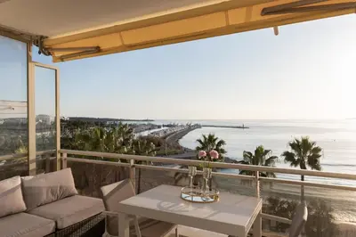 a balcony with a table and a view of the ocean at On la Croisette: luxe 2 bedrooms/ 2 baths in Cannes