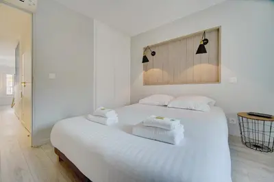 a bedroom with a white bed with towels on it at IMMOGROOM - AC - 5min from the beaches 8 min from Palais in Cannes