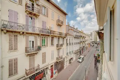 a city street with buildings and a car on the road at IMMOGROOM - AC - 5min from the beaches 8 min from Palais in Cannes