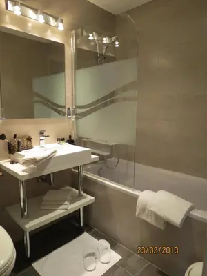 a bathroom with a sink and a toilet and a tub at Hôtel Ligure in Cannes