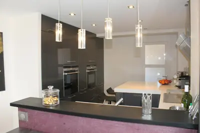 a kitchen with black and white appliances and a counter at Rooftop grande terrasse jacuzzi vue mer in Cannes