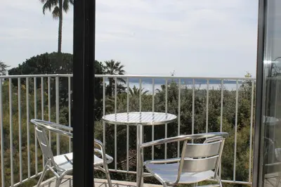 a patio with a table and chairs on a balcony at Rooftop grande terrasse jacuzzi vue mer in Cannes