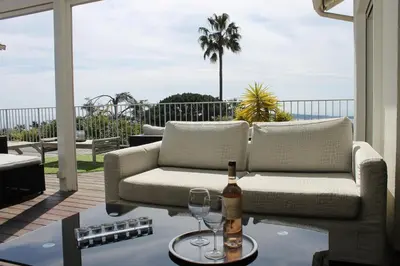 a living room with a couch and wine glasses on a table at Rooftop grande terrasse jacuzzi vue mer in Cannes